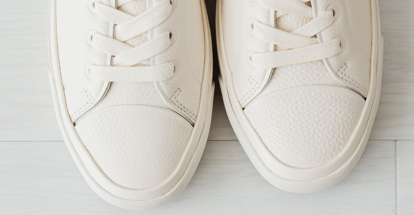 Close view of the white pebbled full-grain leather, cap toe, waxed laces, and stitched cupsole.